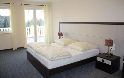 a bedroom with a large bed and a large window at Hotel Helena in Neu Wulmstorf