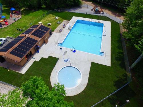 an overhead view of a swimming pool with solar panels at Mt. Maplewood Split Chalet in Pocono Lake