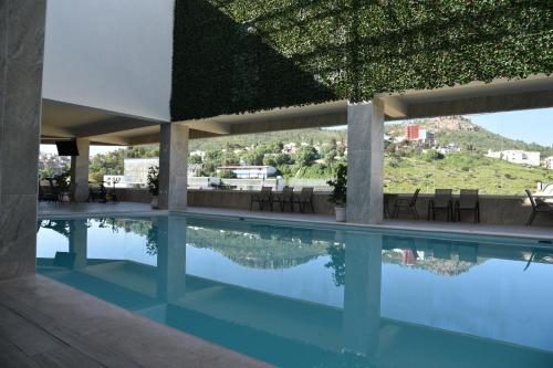 a swimming pool in a building with a green roof at Don Miguel in Zacatecas