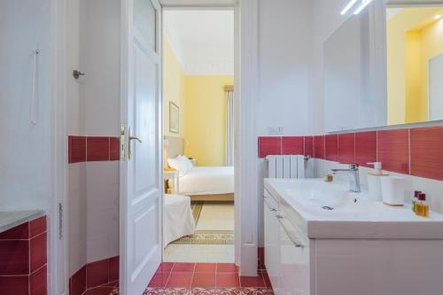 Un baño con lavabo, espejo y bañera. en La Giulietta - Penthouse, en Salerno