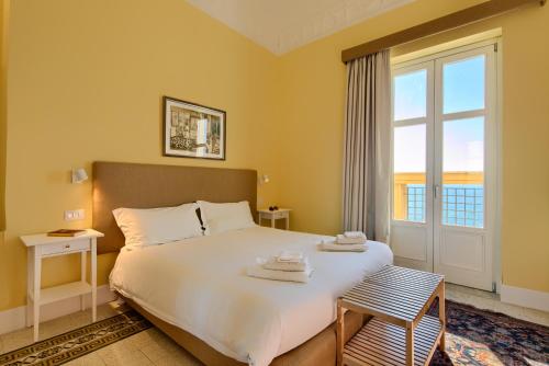Un dormitorio con una gran cama blanca con ventana. en La Giulietta - Penthouse, en Salerno