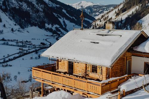 a church covered in snow with a cross on the roof at Rauriser Bergchalet in Rauris