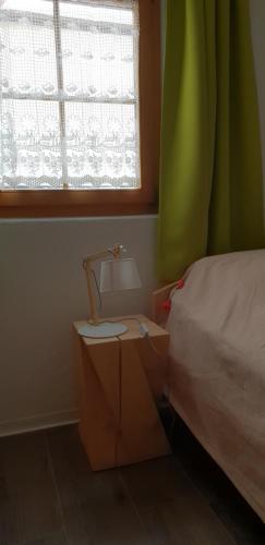 a bedroom with a bed and a table and a window at Chasa Melchior in Zernez