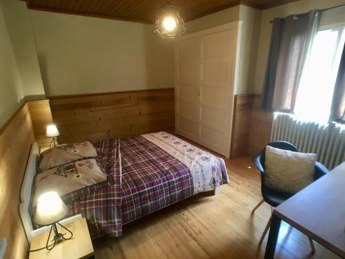 1 dormitorio con 1 cama, 1 mesa y 1 silla en Neige & Soleil Les Rousses, en Les Rousses