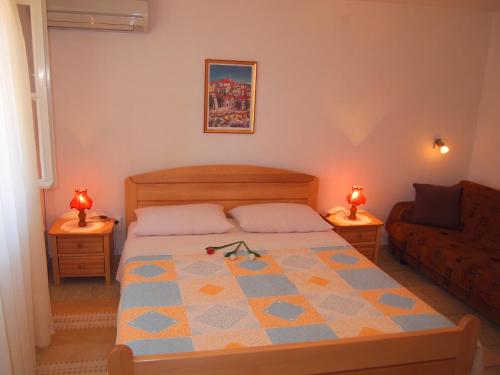 a bedroom with a bed and a couch at Apartments Lumbarda Beach in Lumbarda