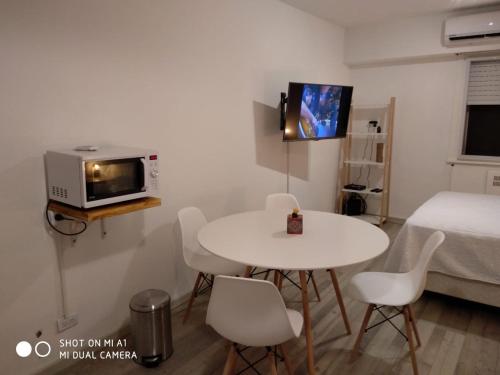 Habitación pequeña con mesa y microondas. en Avenida Corrientes Studio - Obelisco en Buenos Aires