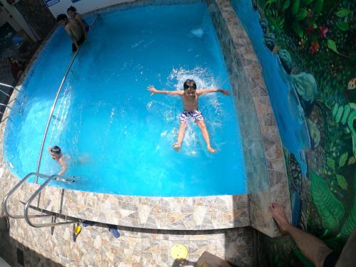 un ragazzo che nuota in piscina di Residencial Marina House a Tarapoto