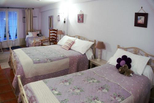 sypialnia z dwoma łóżkami i pluszowym misiem na górze w obiekcie Domaine de la chapelle - Ch d'hote w mieście Faverolles-sur-Cher