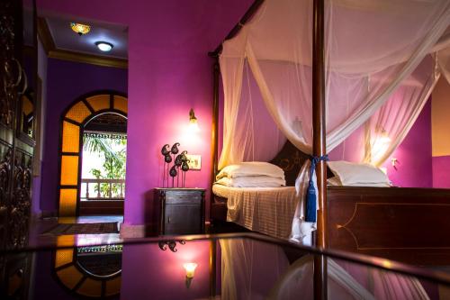 a room with a bedroom with a canopy bed at Papa Jolly Eco Resort-Near Morjim Beach in Morjim