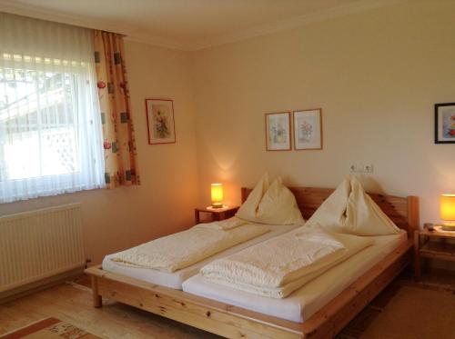SchlierbachにあるHaus Margitのベッドルーム1室(大型ベッド1台、ランプ2つ付)