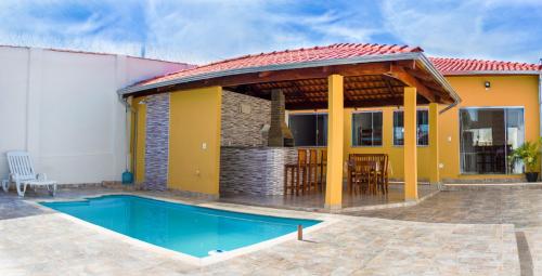 een villa met een zwembad en een huis bij Pouso Oliveira Casa com ar condicionado in São João Batista do Glória
