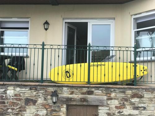 a yellow surfboard is sitting on a balcony at Beachy in Newquay