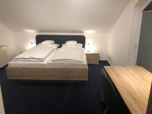 a bedroom with a large bed with white sheets and pillows at Gasthof Zur Krone in Leidersbach