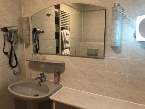 a bathroom with a sink and a mirror at Gasthof Zur Krone in Leidersbach