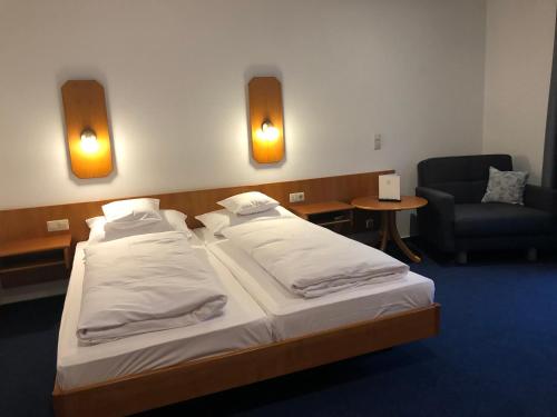 a hotel room with a bed and a chair and lights at Gasthof Zur Krone in Leidersbach