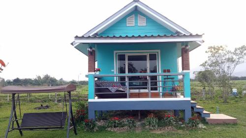 a blue house with a porch and a chair at Ban Thung Talay Mok Chiangdao in Chiang Dao