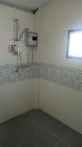 a bathroom with a shower in a white wall at Ban Thung Talay Mok Chiangdao in Chiang Dao