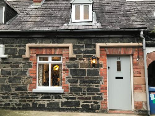 a brick building with a white door and a window at Arthur Street Guest Cottage No16 in Hillsborough