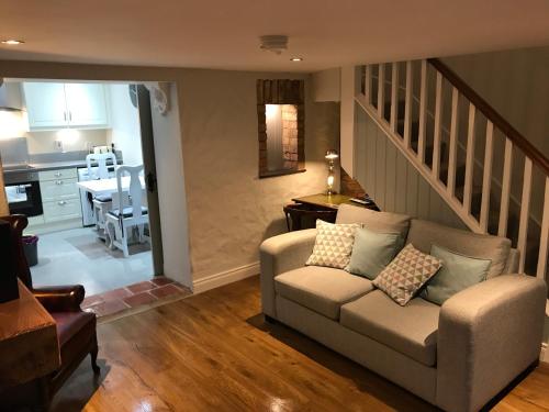 a living room with a couch and a kitchen at Arthur Street Guest Cottage No16 in Hillsborough