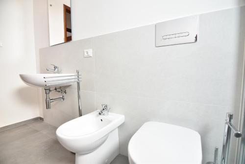 La salle de bains blanche est pourvue de toilettes et d'un lavabo. dans l'établissement Center Beach, à Marina di Ragusa