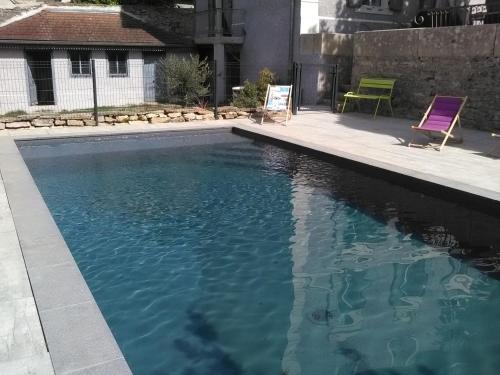 - une piscine avec 2 chaises longues à côté dans l'établissement A deux pas du Rheby, à Villebois