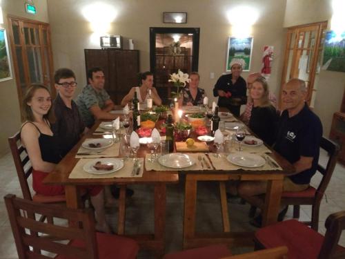 a group of people sitting around a wooden table at Posada Cavieres Wine Farm in Maipú