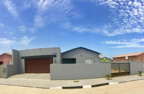 a house with a fence in front of it at Man Cave Suite in Swakopmund