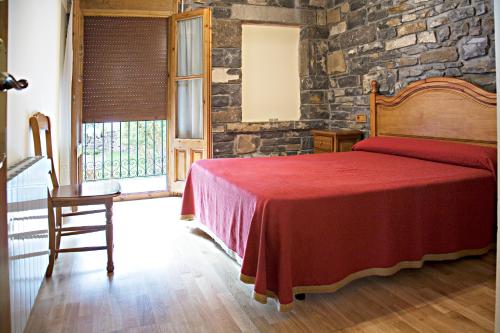 a bedroom with a bed and a stone wall at Apartamentos Casa Buisan in Broto
