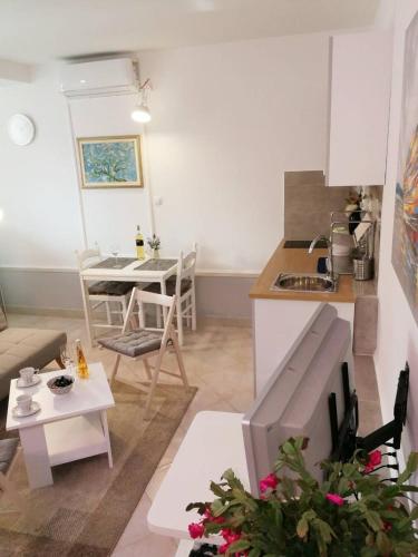 a small living room with a kitchen and a table at Apartman Unka in Metković