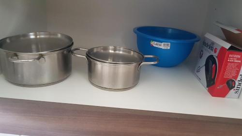 two metal pots on a counter next to a blue bucket at Los robles II Pucon Casa Preciosa, FULL EQUIPADA in Pucón