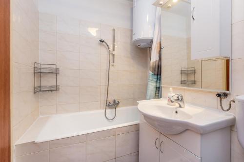 a white bathroom with a sink and a shower at Apartment Infinity in Rijeka