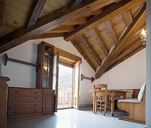 a dining room with a table and a wooden ceiling at Apartamentos Casa Buisan in Broto