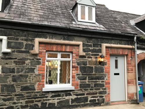 a brick house with a white door and a window at Arthur Street Guest Cottage No16 in Hillsborough