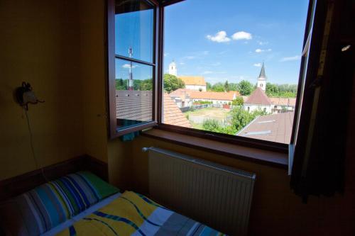 a bedroom with a window with a view of a church at Penzión pri Kaštieli in Bratislava