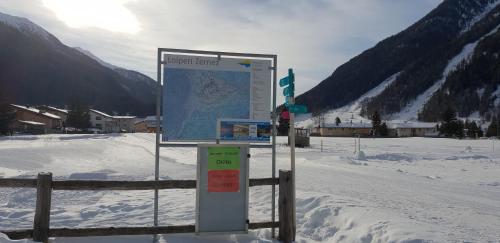 a sign in the snow next to a fence at Chasa Melchior in Zernez