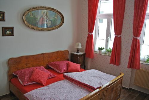 a bedroom with a bed with red pillows on it at Restaurace a penzion Ubrousku prostři se in Nová Bystřice