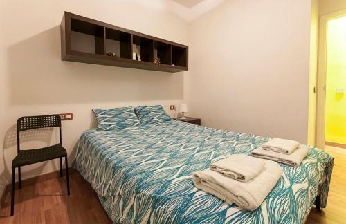 a bedroom with a bed and a chair with towels on it at Céntrico y tranquilo apartamento con WIFI in Santa Cruz de Tenerife