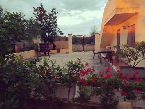 a patio with flowers and a table and a fence at Agriturismo Tenuta La Siesta in Gallipoli
