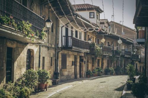 Cartes的住宿－Apartamentos Las Alas，一条有植物的古老建筑中的空街