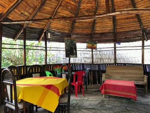 a restaurant with tables and chairs and a wooden roof at Zion Train Lodge Shashemene in Kʼorē