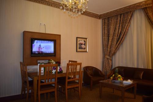 a living room with a table and a couch and a television at Canary Beach Hotel in Yanbu