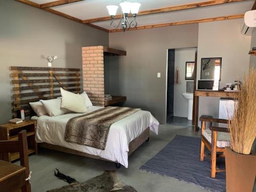 a bedroom with a bed and a bathroom at Country Lodge in Upington