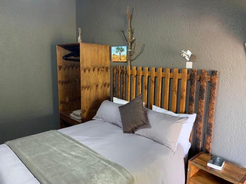 a bed with a wooden headboard in a bedroom at Country Lodge in Upington
