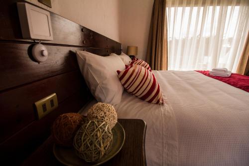 a hotel room with a bed with pillows and a table at Hotel El Molino in Santa Cruz