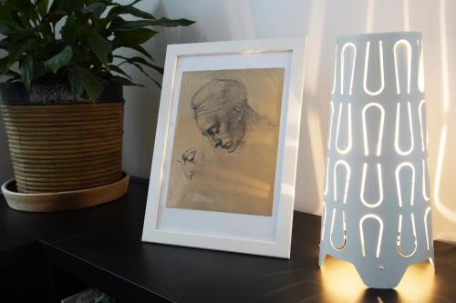 a picture frame sitting on a table next to a plant at APARTMÁN V ZAHRADĚ PRAHA TROJA - APARTMENT IN THE GARDEN PRAGUE Troja in Prague