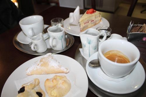 a table with plates of food and a cup of coffee at Rivendell Apartments in Prague