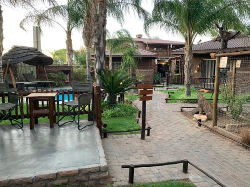 a patio with a table and chairs and trees at Country Lodge in Upington