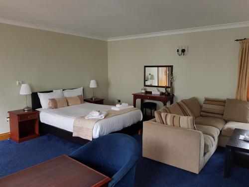 a hotel room with a bed and a couch at The Swan Inn in Hilborough