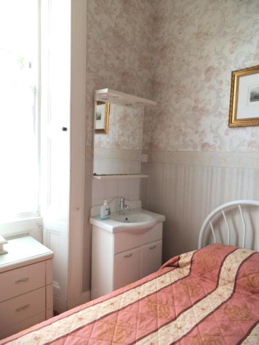 a bedroom with a bed and a sink and a mirror at Menzies Guest House in Edinburgh