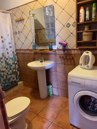 a bathroom with a washing machine and a sink at Casa Tanajara in El Pinar del Hierro